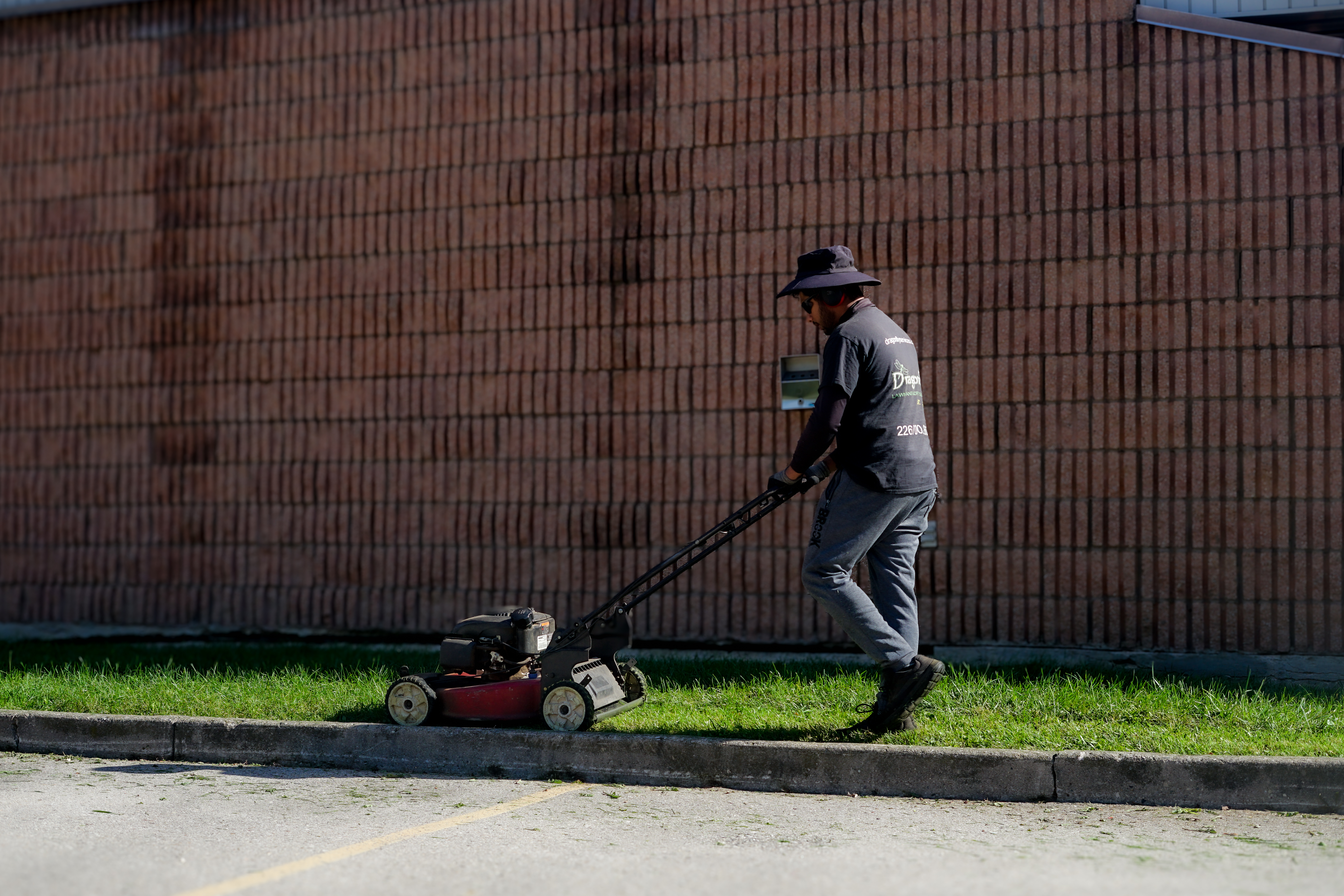 Man using grass removal machine to clear lawn