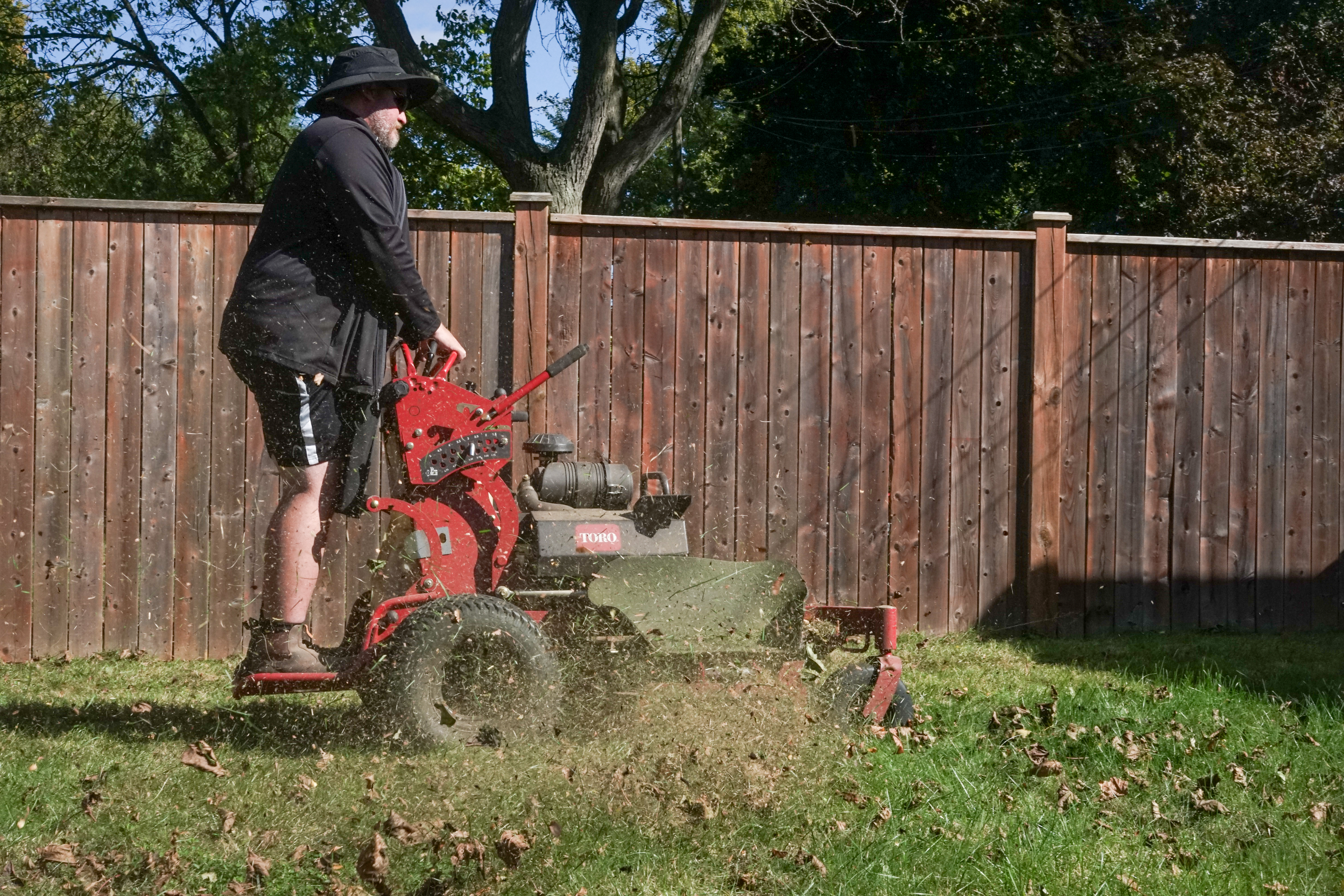 Man using grass removal machine to clear lawn
